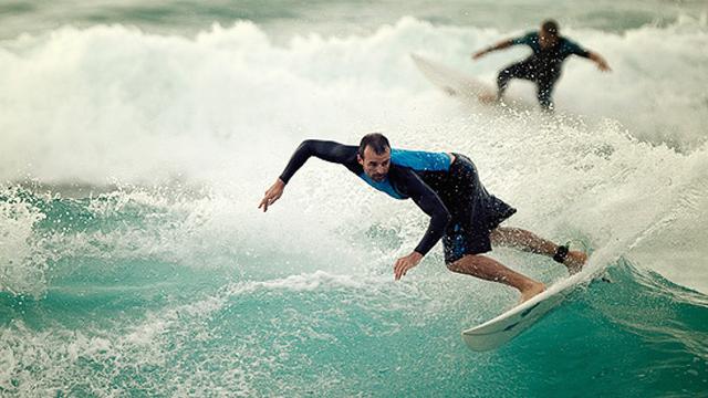 Surfer, foreground, on a reform wave