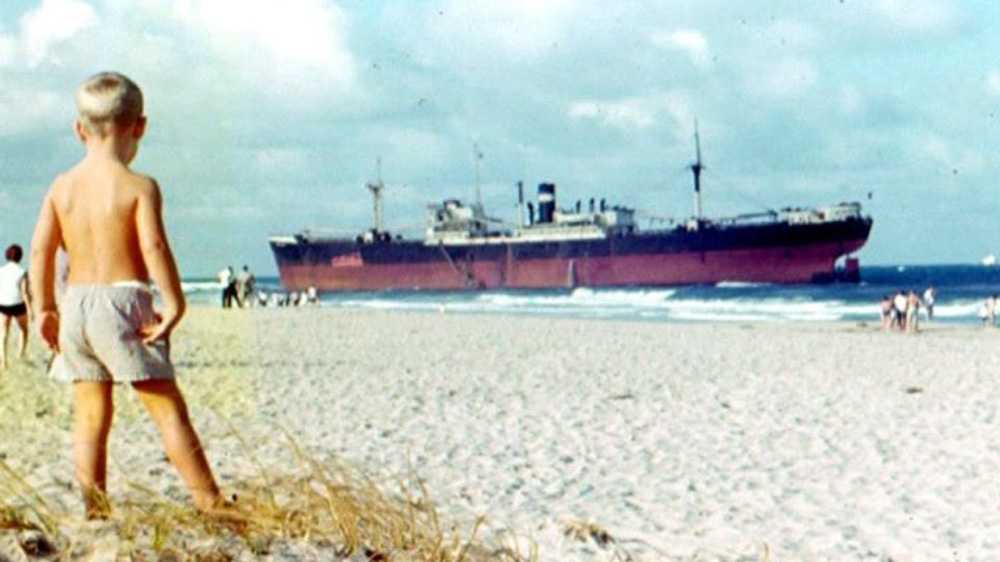 beach scene in florida with shipwreck and surfing