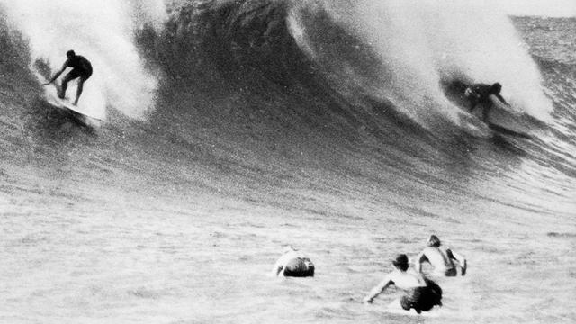 Three surfers kneepaddling at Sunset Beach, early '60s. Photo: Severson