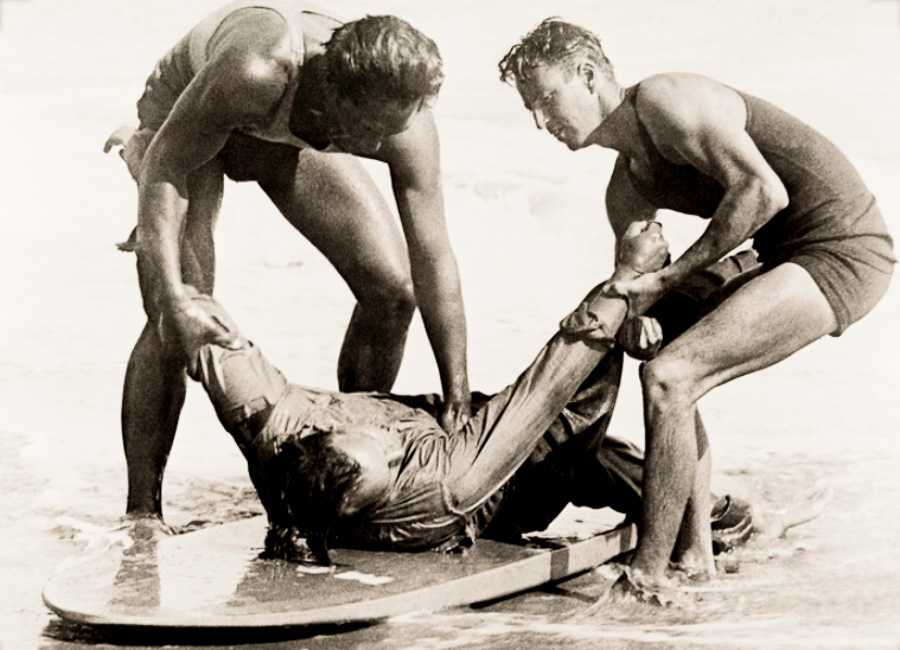 Duke Kahamoku and Bill Herwig reenact their rescue, with Owen Hale as victim