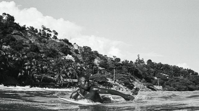 Samuel Jules, paddling out for Haiti's first surf competition. Photo: Michael Magars