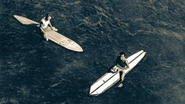 Two surfers outside the lineup at Makaha, in the late 1940s, waiting for waves