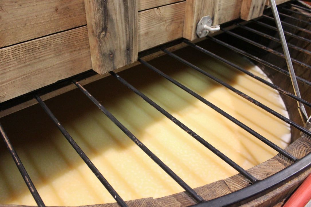 Mash fermenting in an open wooden vat under a steel grate