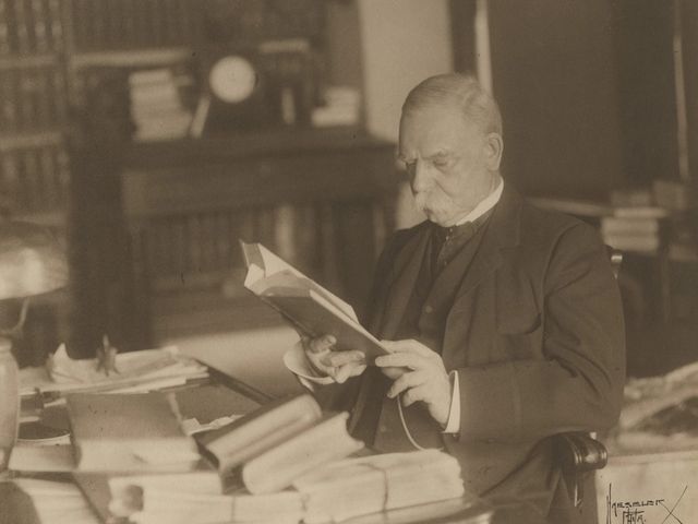 Black and white photograph of John G. Johnson reading a book