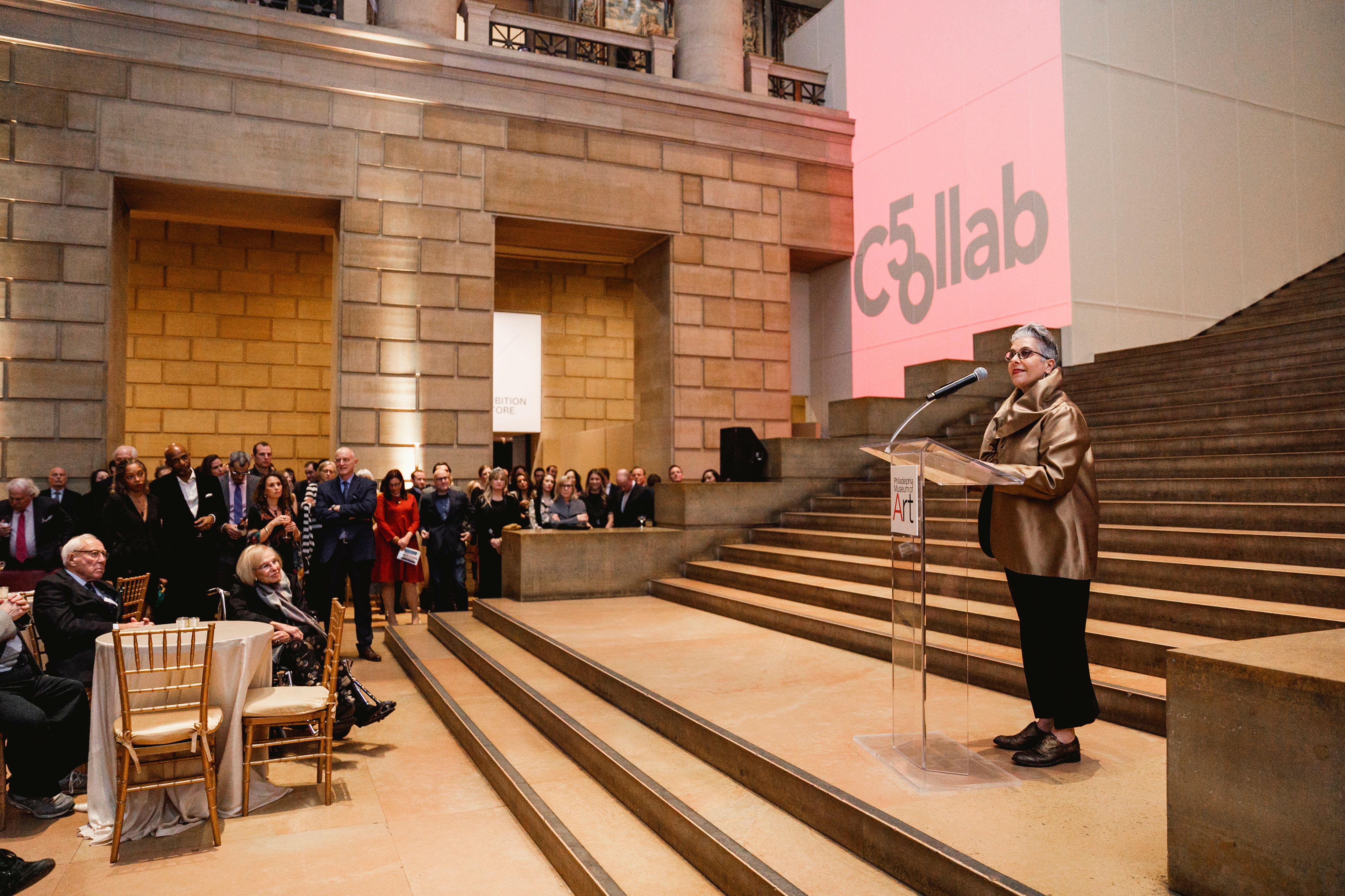 Speaker talking to an audience on the Great Stair Hall steps during the Collab 50th Anniversary Gala