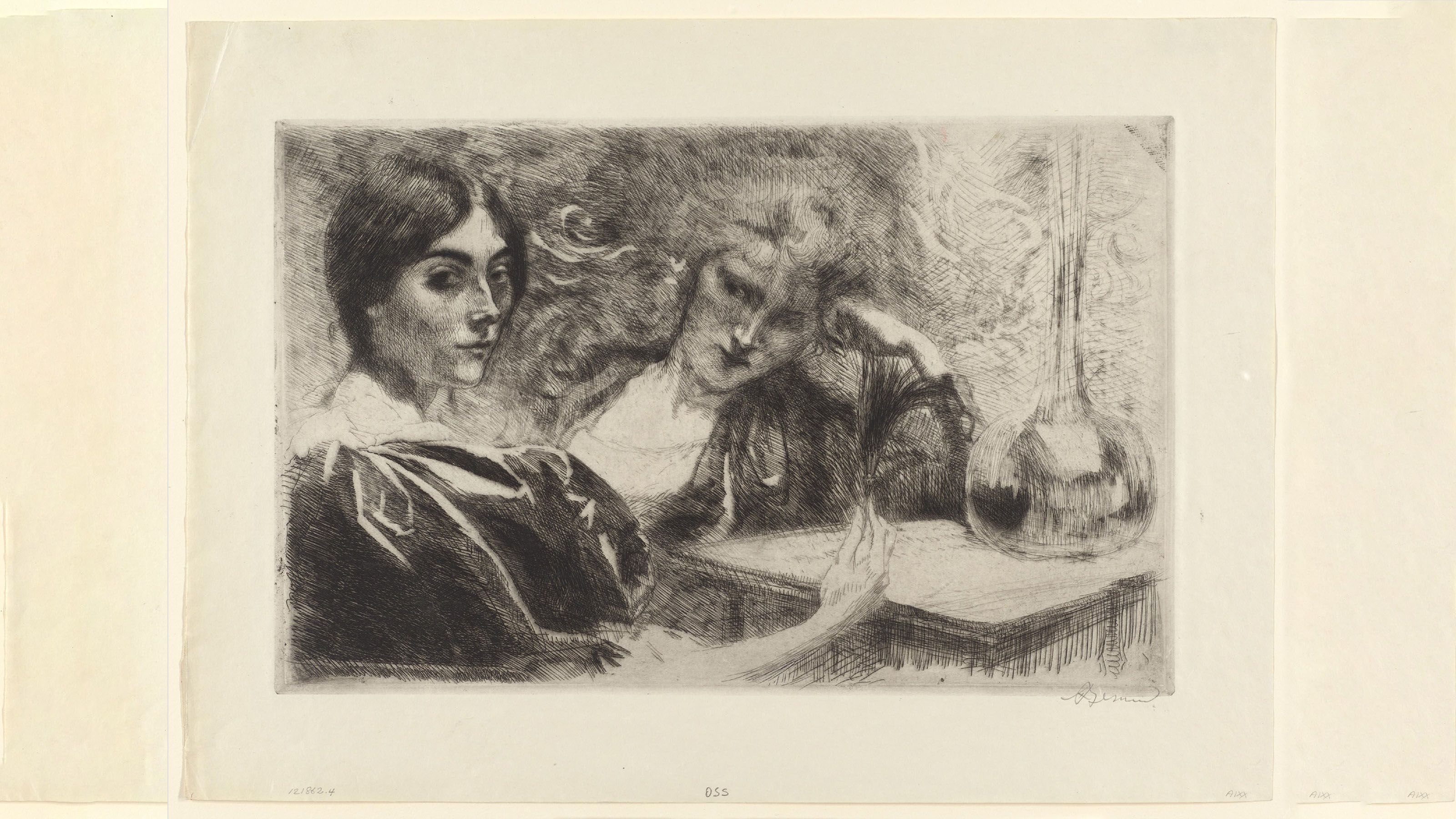 Two women sitting at a small table, one is holding a feather and looking at the viewer.