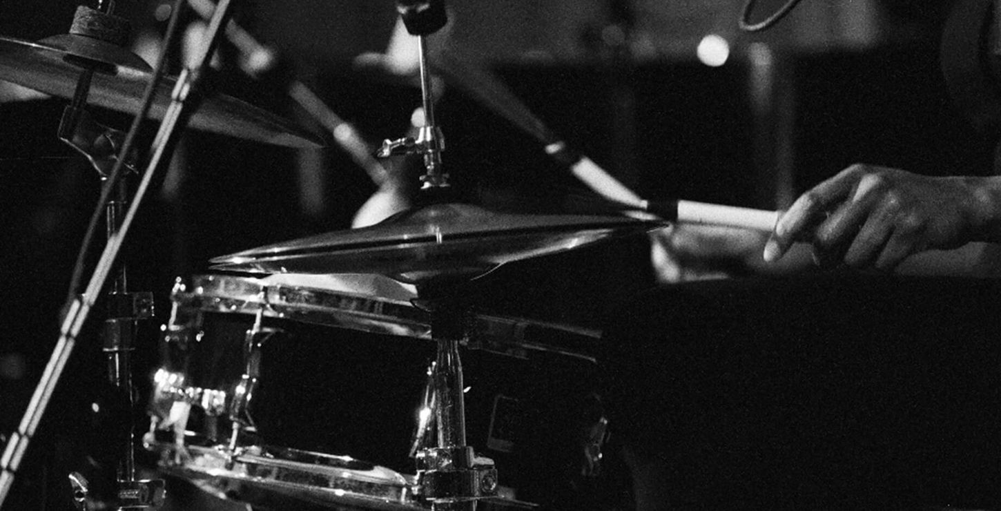 Black and white close up photograph of a drummer playing the drums.