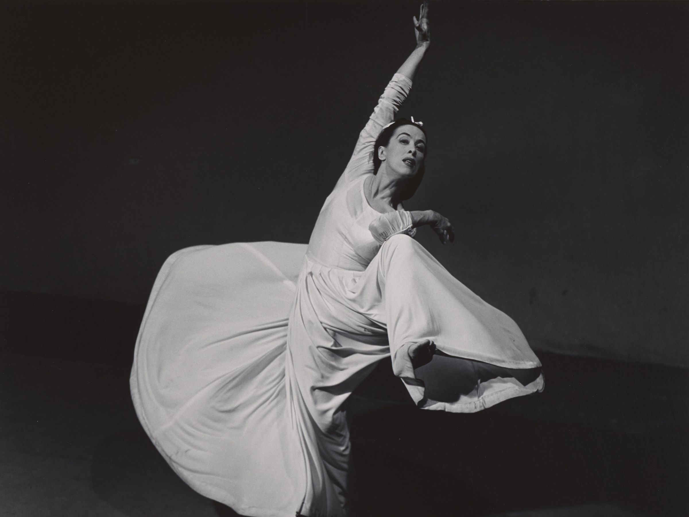 Photograph of Martha Graham middance, her clothes billowing around her.