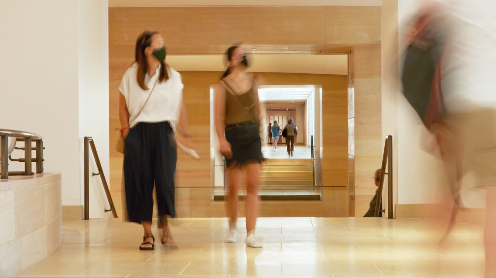 Two masked visitors walking in the galleries.