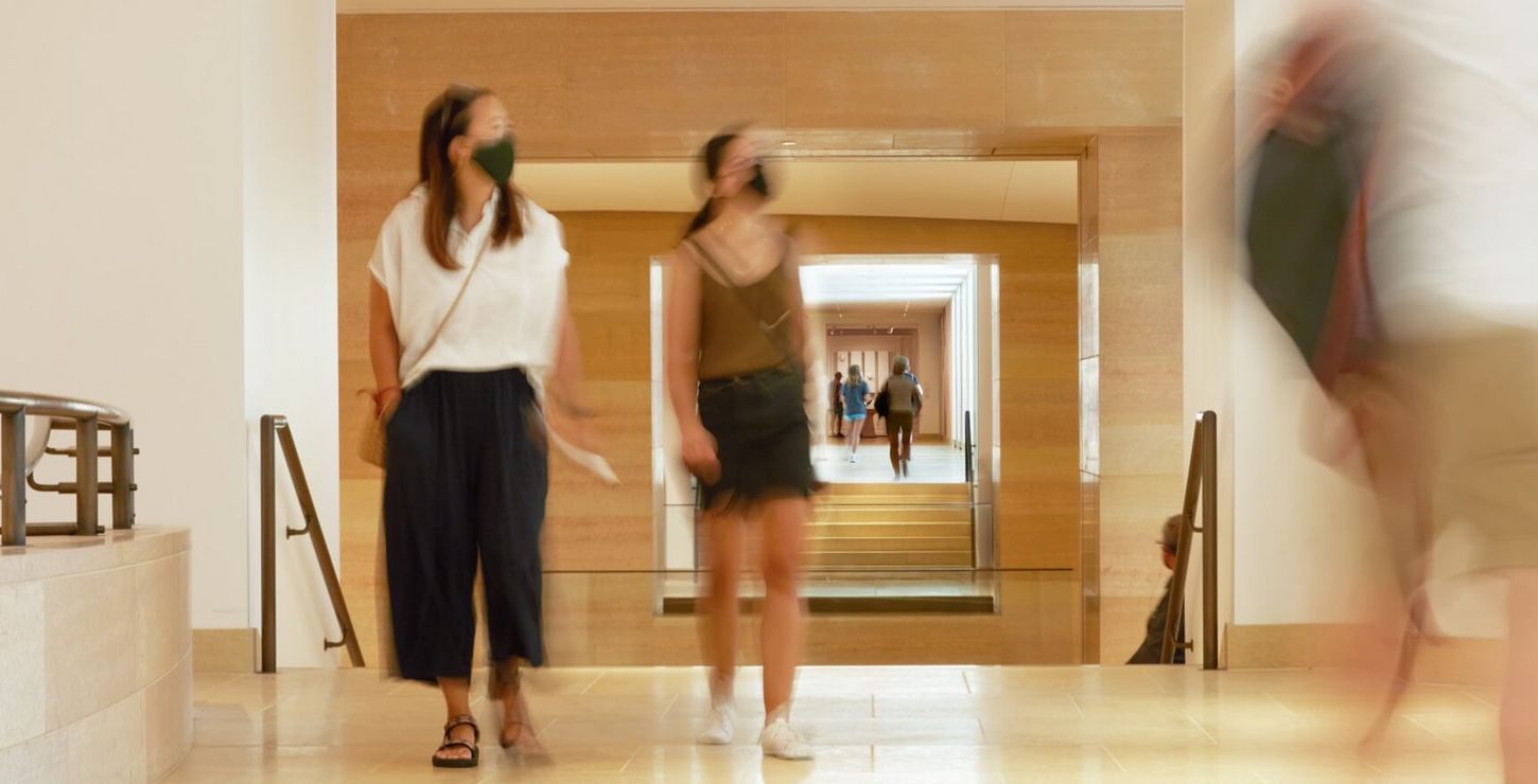 Two masked visitors walking in the galleries.