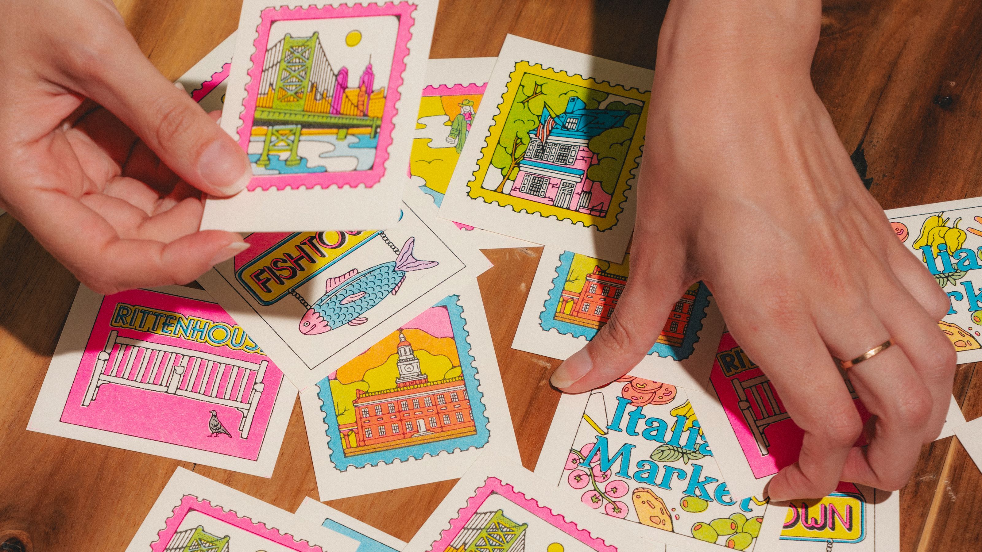 Close up of Fabiola Lara's hands sorting through her custom mini prints inspired by Philadelphia.