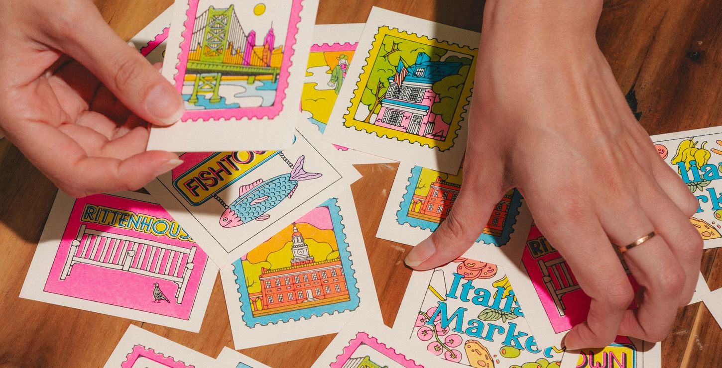 Close up of Fabiola Lara's hands sorting through her custom mini prints inspired by Philadelphia.