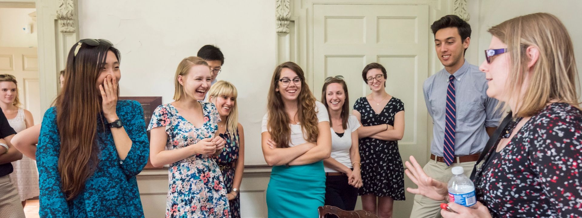 A group of interns laughing and taking a tour of the Mount Pleasant historic house
