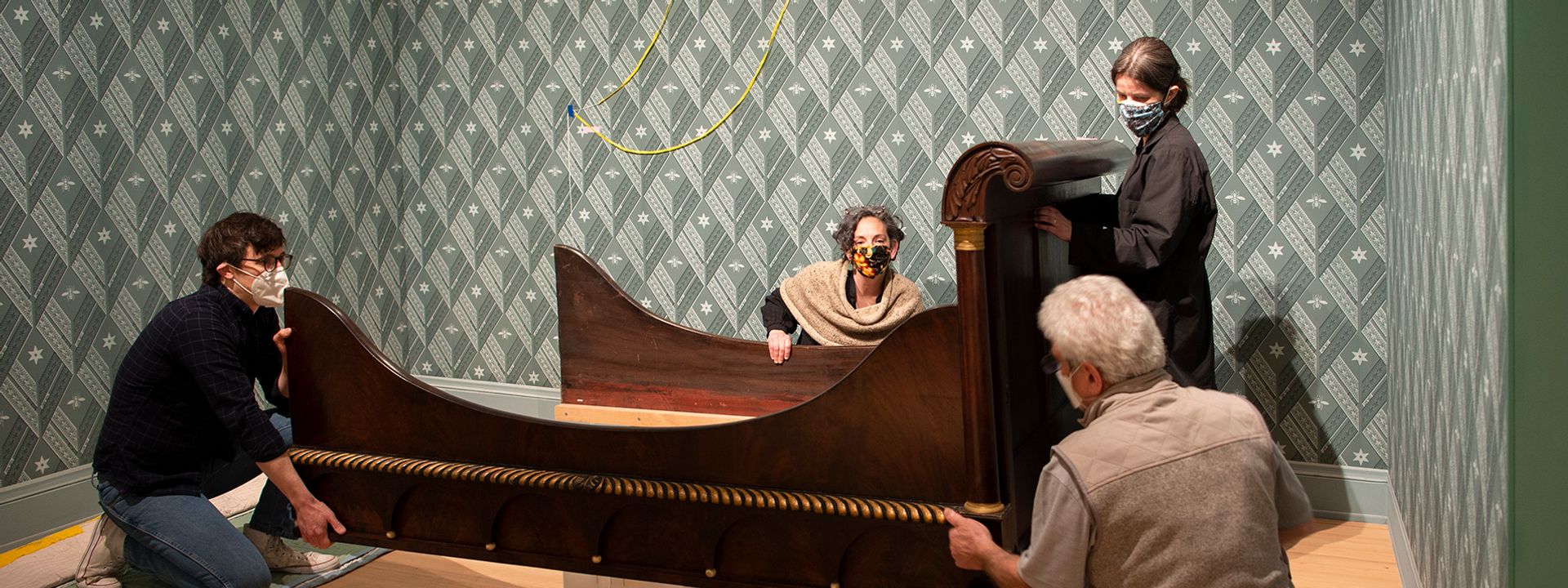 Four conservators building an installation in the new Early American Art galleries