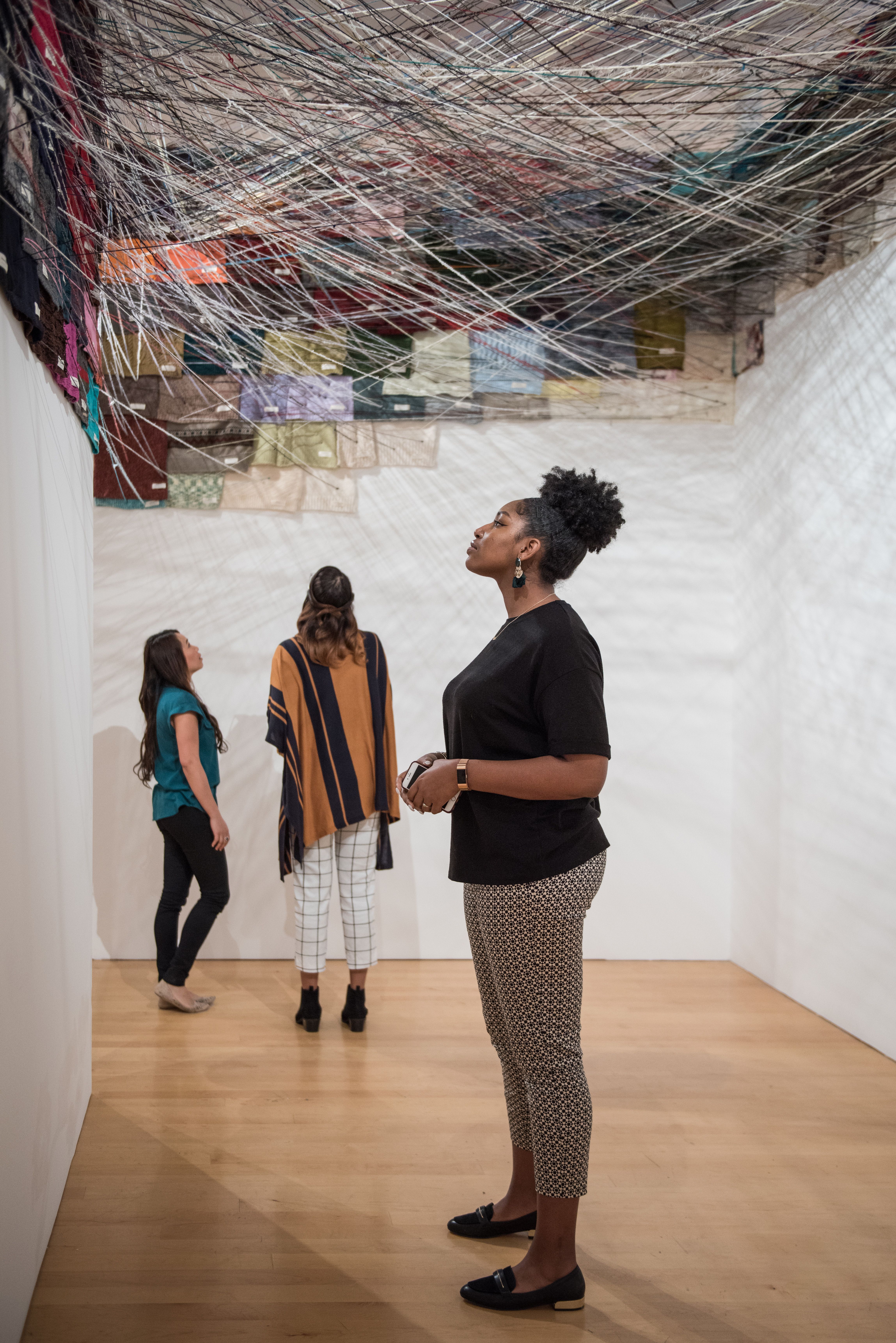 Visitor looking at an installation artwork on the wall of a gallery