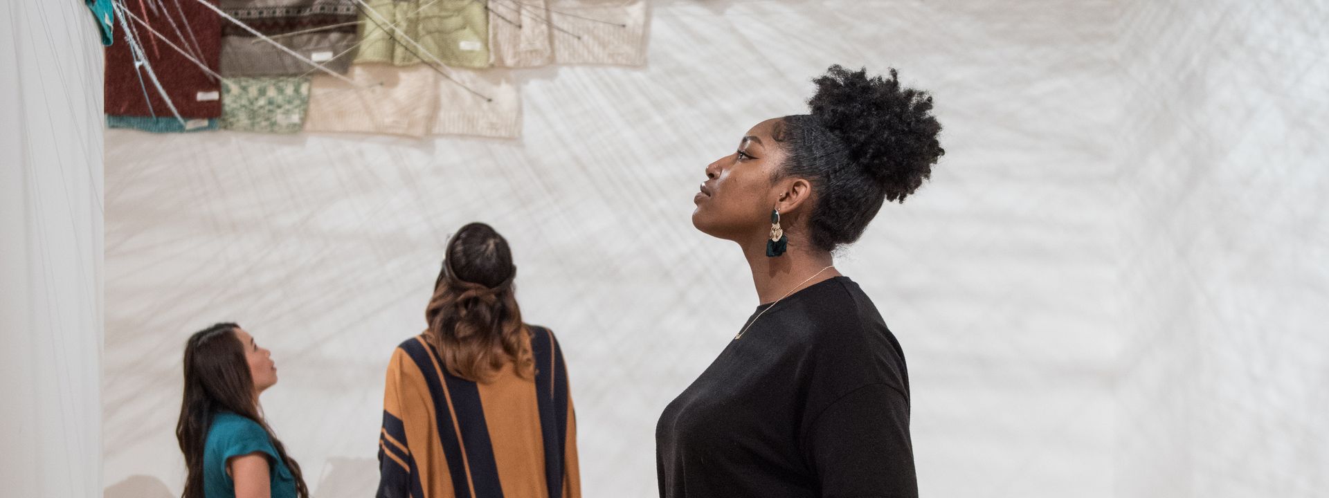 Visitor looking at an installation artwork on the wall of a gallery