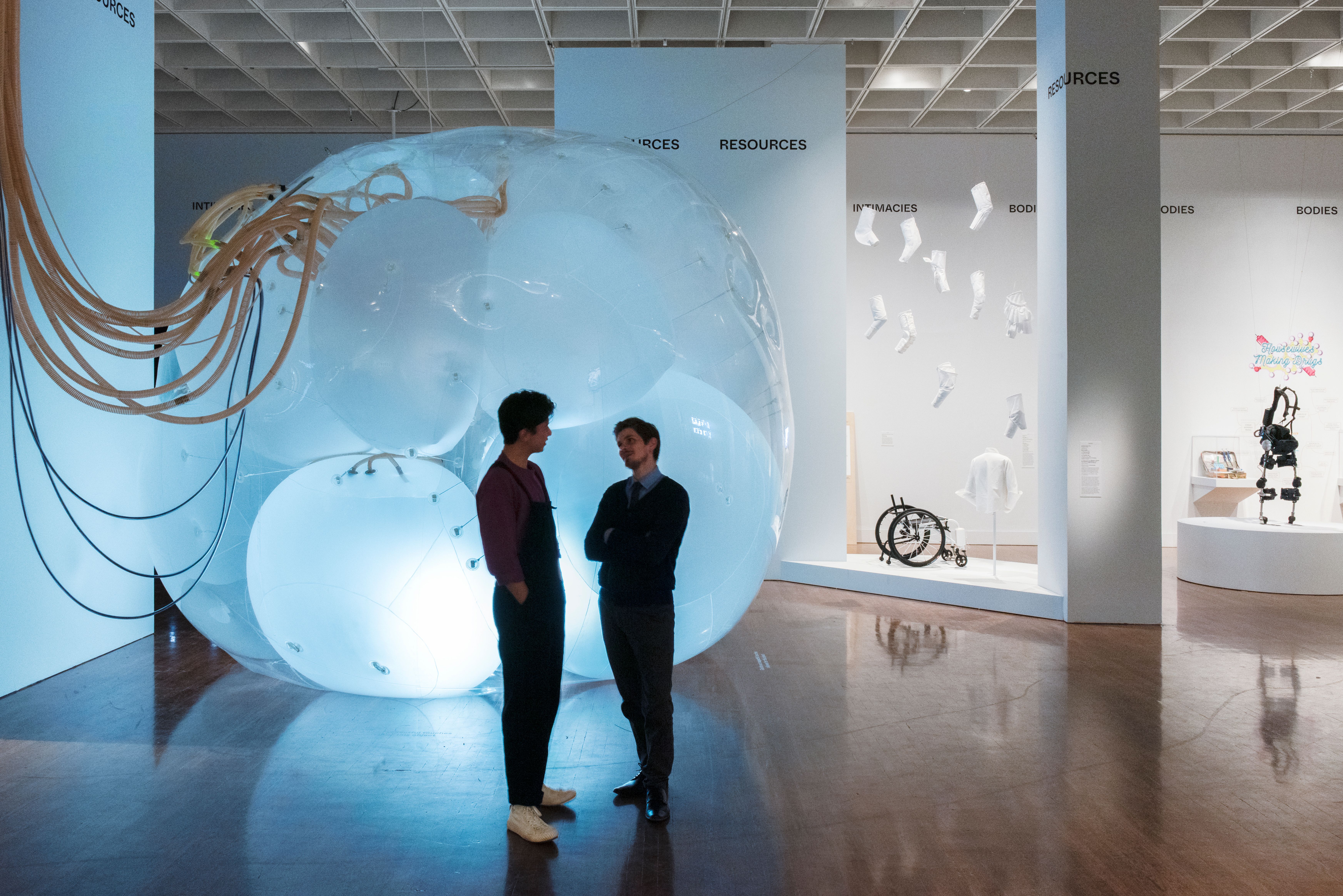 Two visitors standing in front of a large, glowing installation