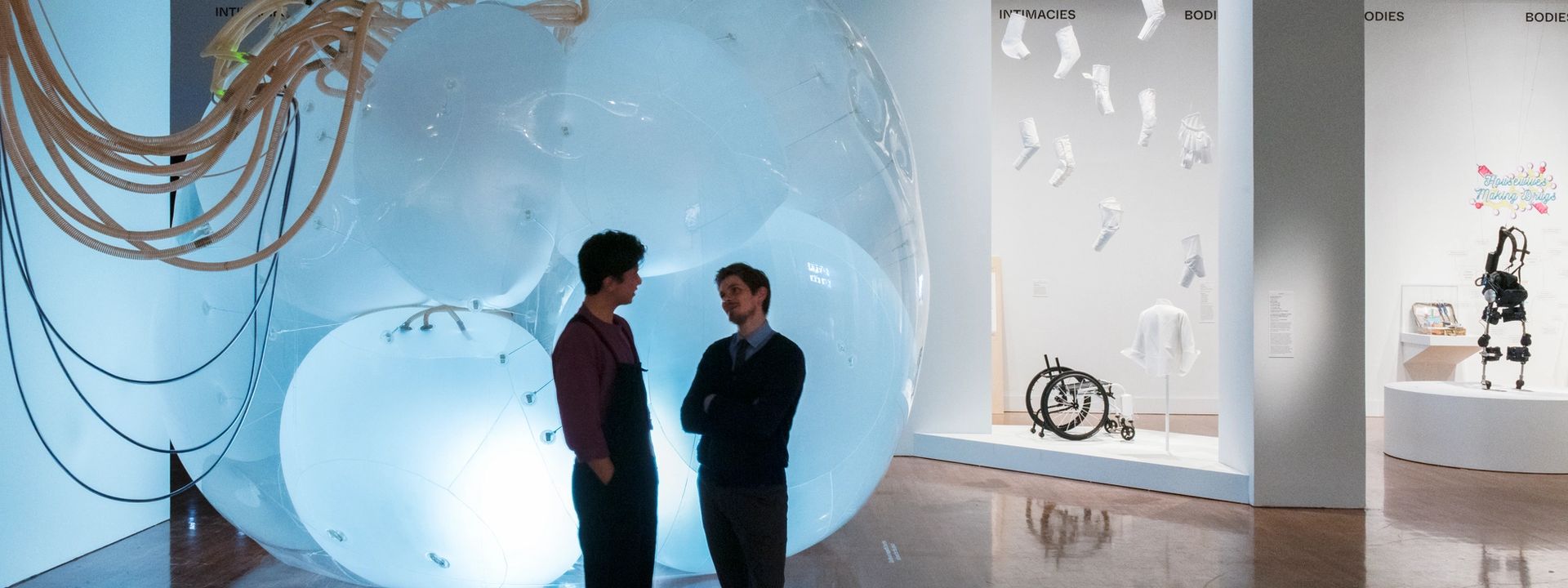 Two visitors standing in front of a large, glowing installation