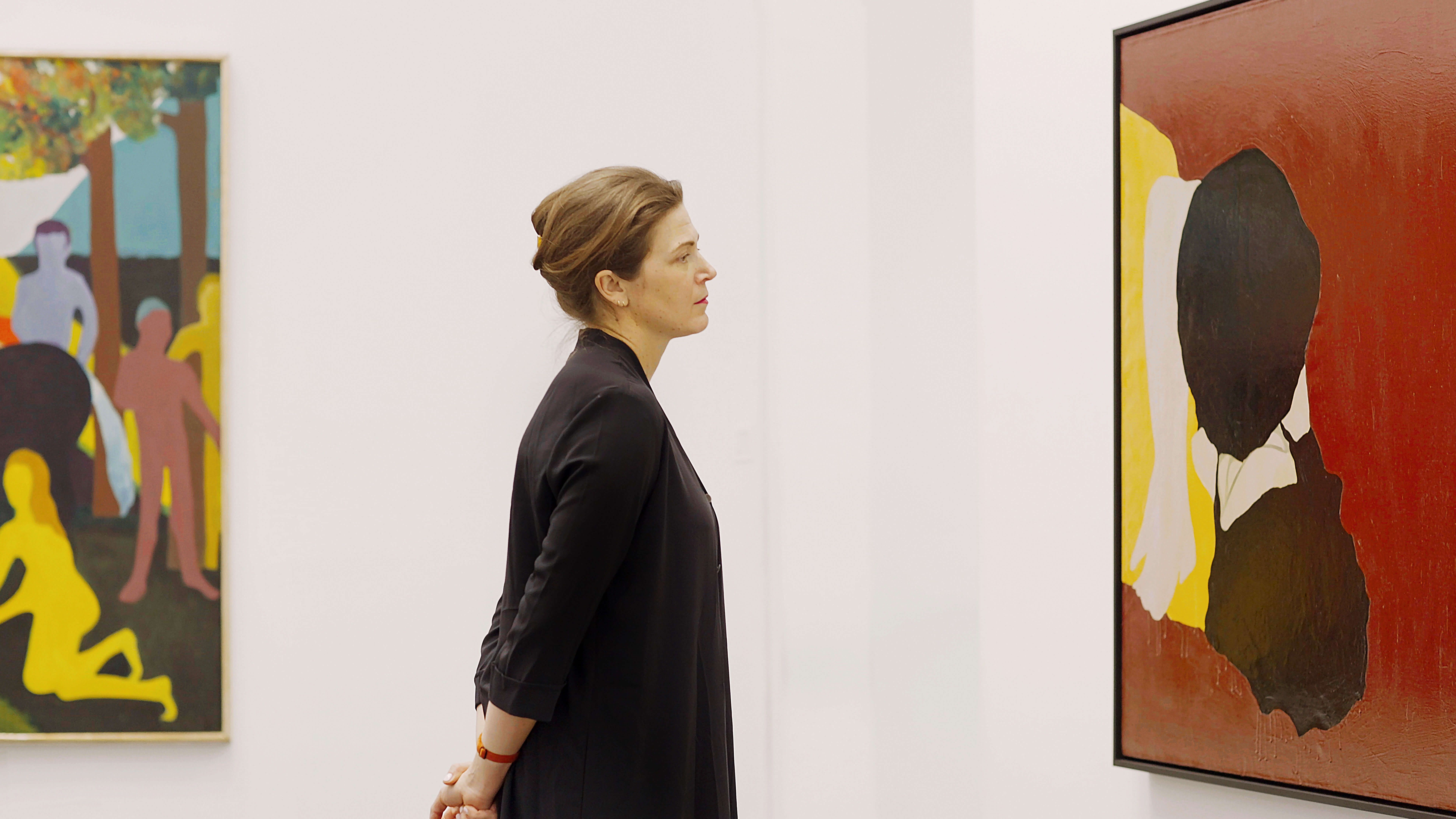 Director Sasha Suda looking at a painting in the galleries.