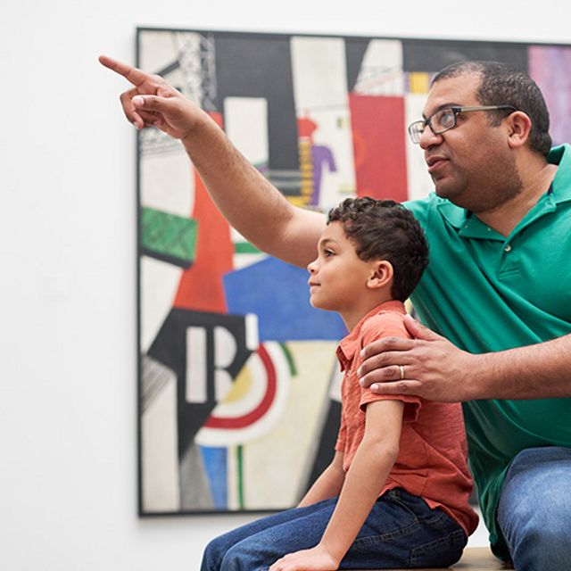 A parent showing his child an artwork