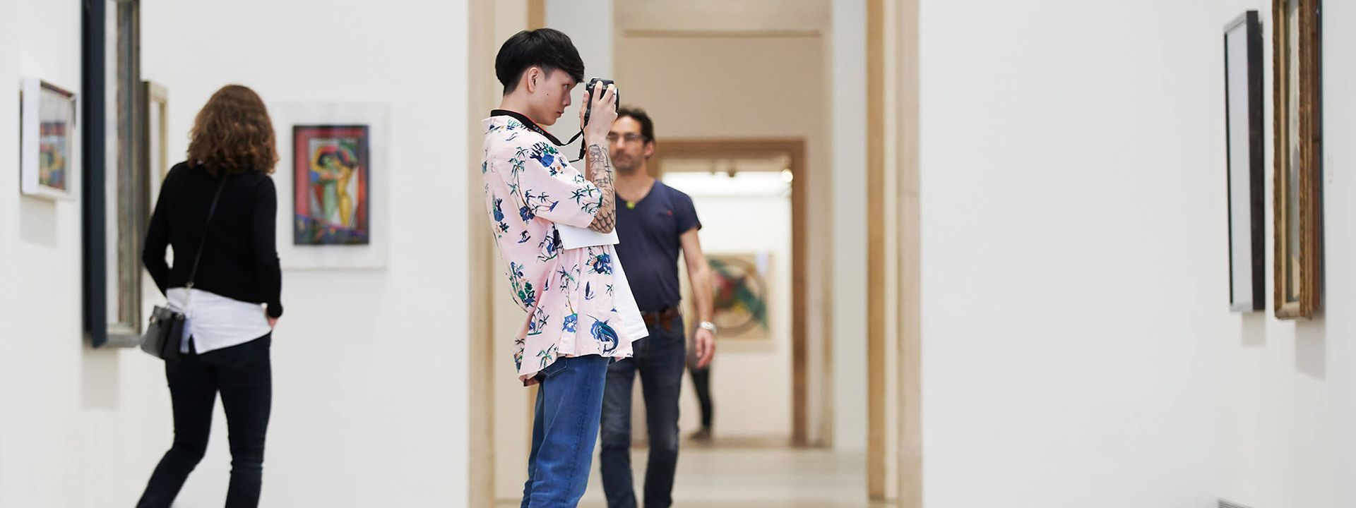 Young man taking a photo with a camera in the galleries