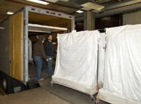 Rolling racks with hanging costume are moved through the old building and loaded onto the truck for transfer to the new storage facility.
