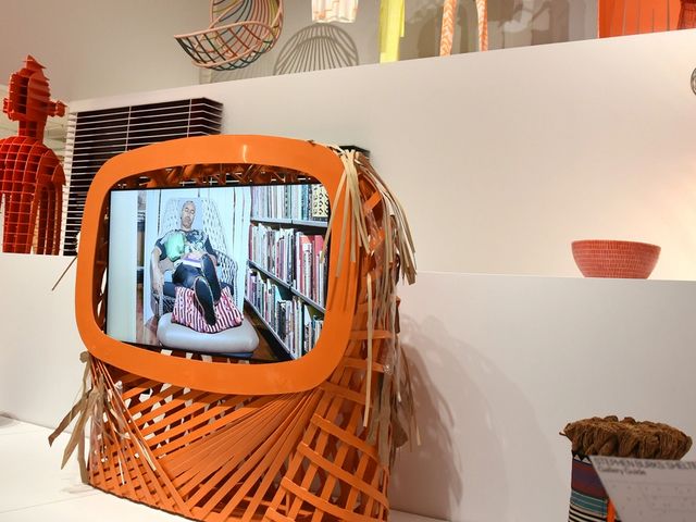 A photograph of various woven objects around a tv with a woven frame.