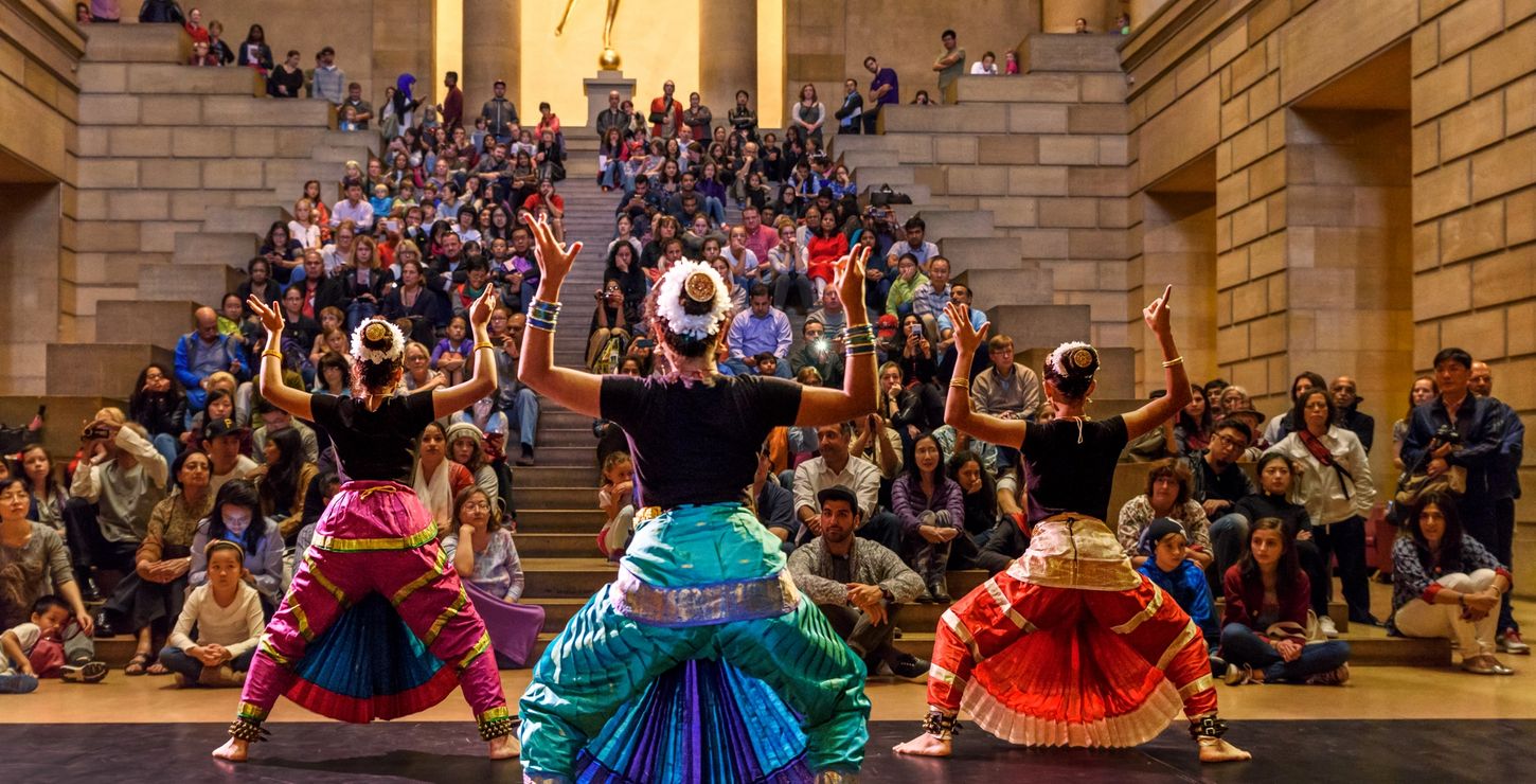 Three performers dancing in front of an audience in the Great Stair Hall