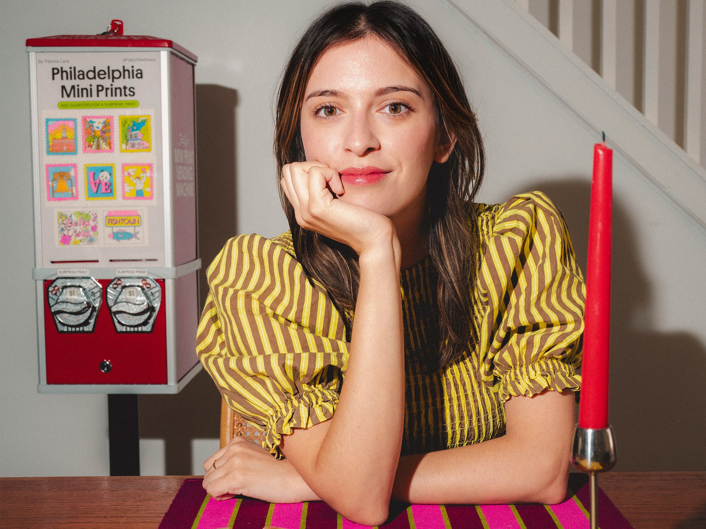 Fabiola Lara smiling with her custom Philadelphia Mini Prints vending machine in the background.