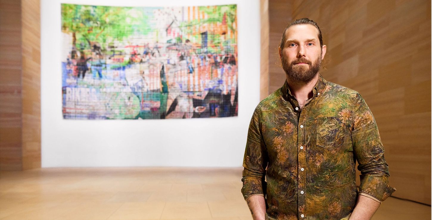 Artist Jesse Krimes standing in front of his work Riker&apos;s Quilt.