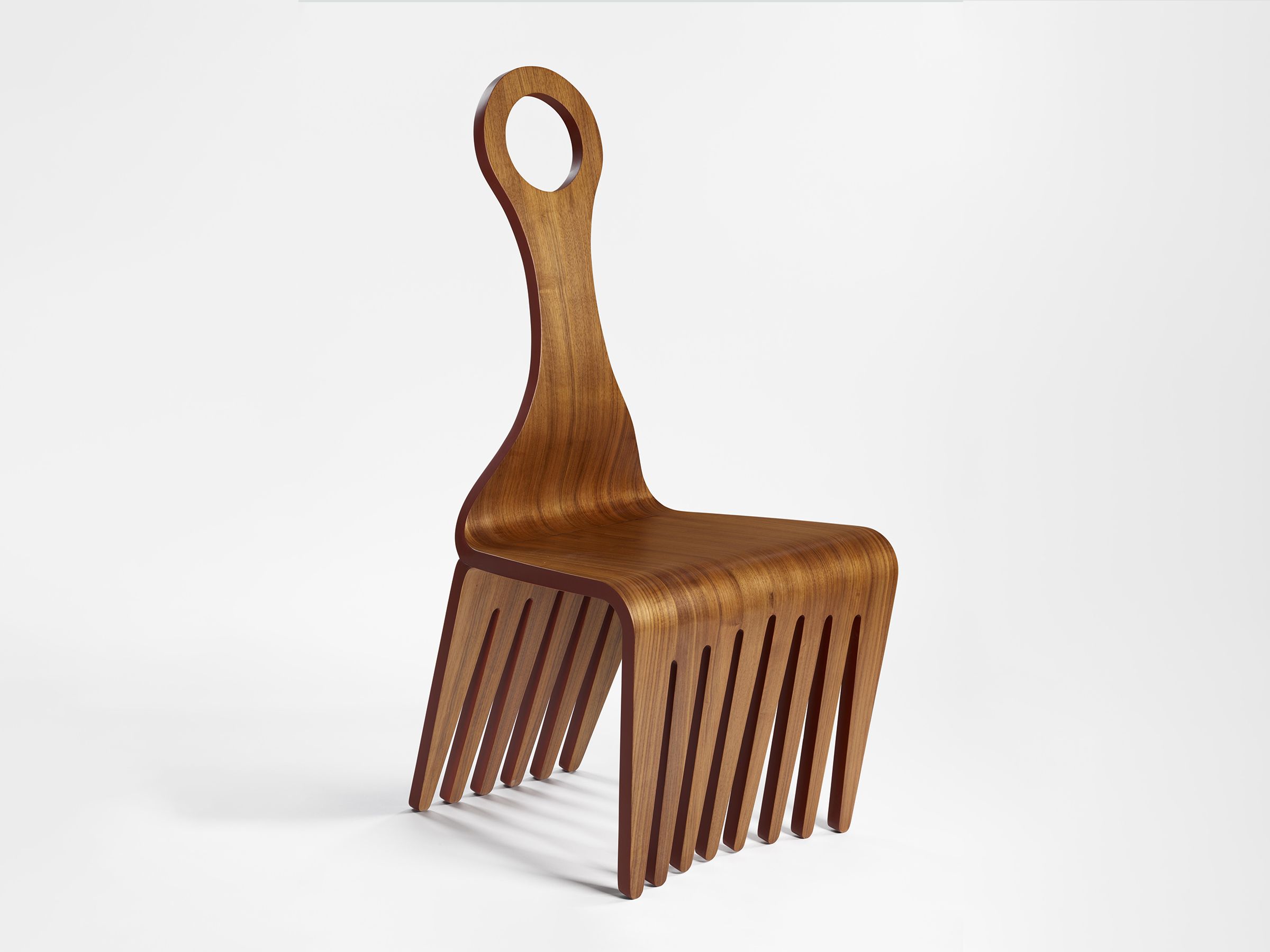 A chair made of walnut veneer, epoxy glue, satin finish, and paint.