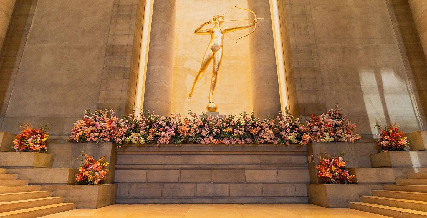 Flower arrangement surrounding a golden statue.