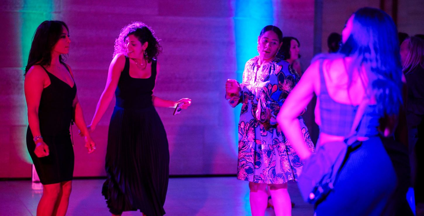 Guests dancing in pink and blue lighting at a party in the Williams Forum.