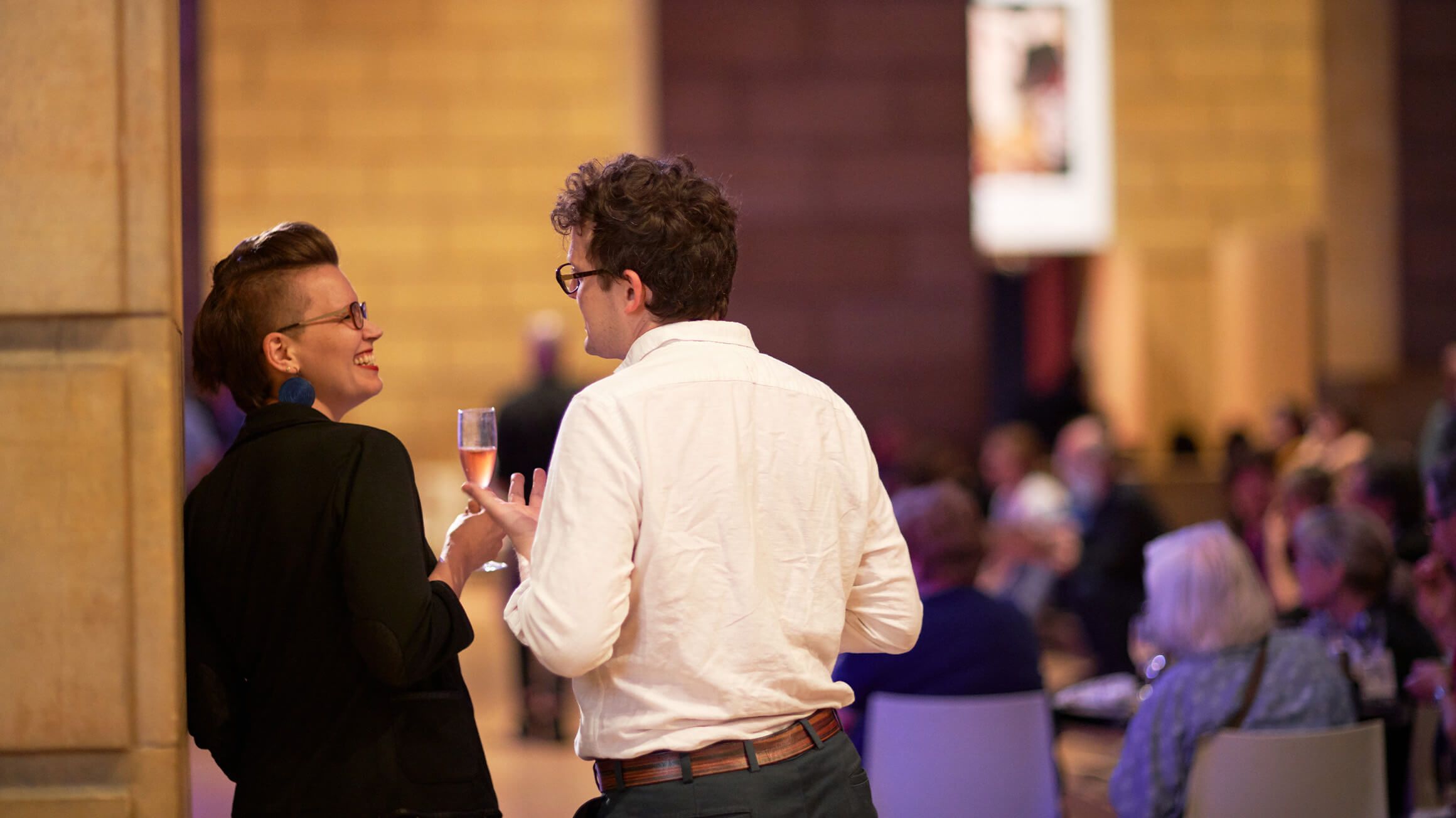 Two people drinking and talking at a party