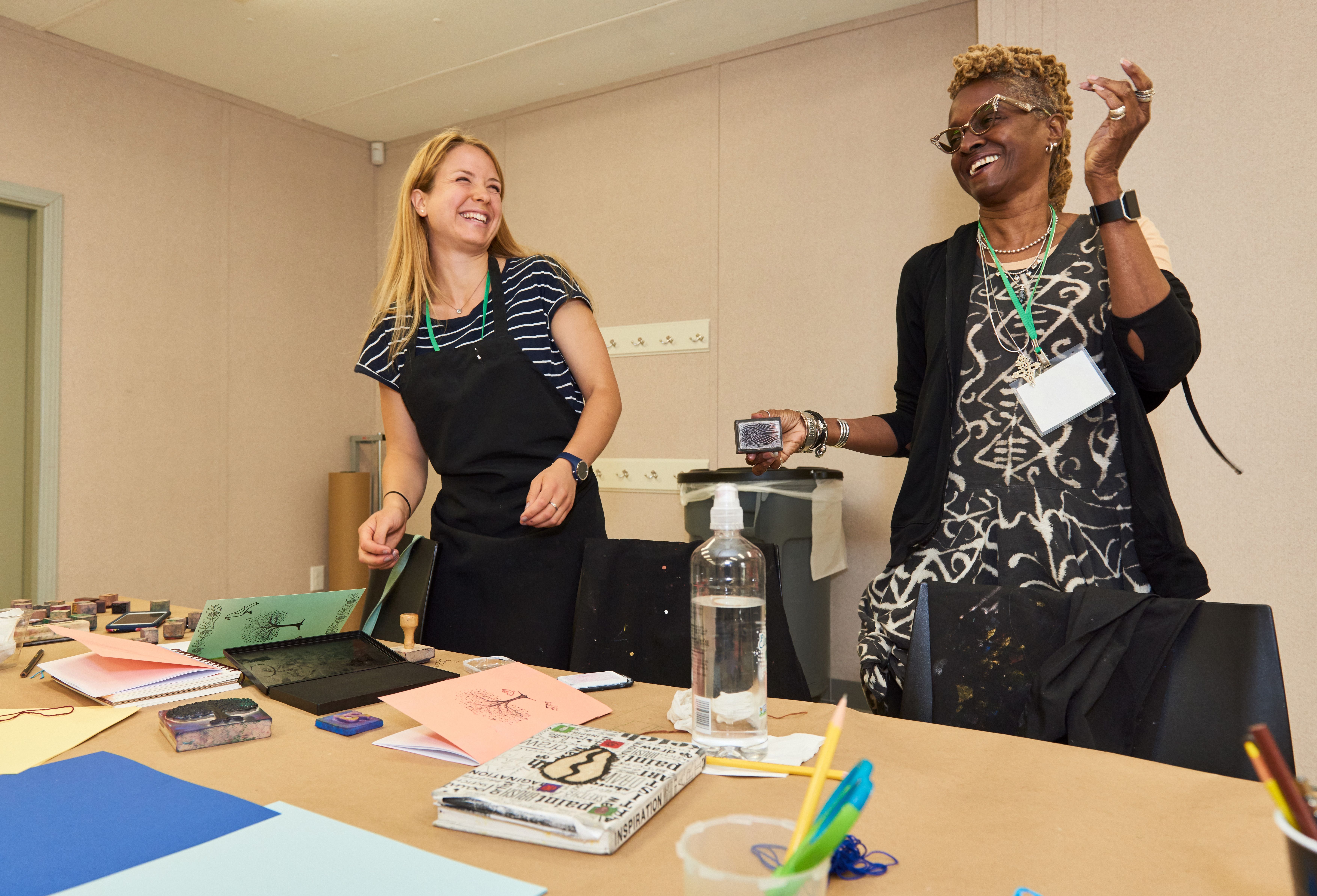 Two teachers laughing together during a teacher workshop