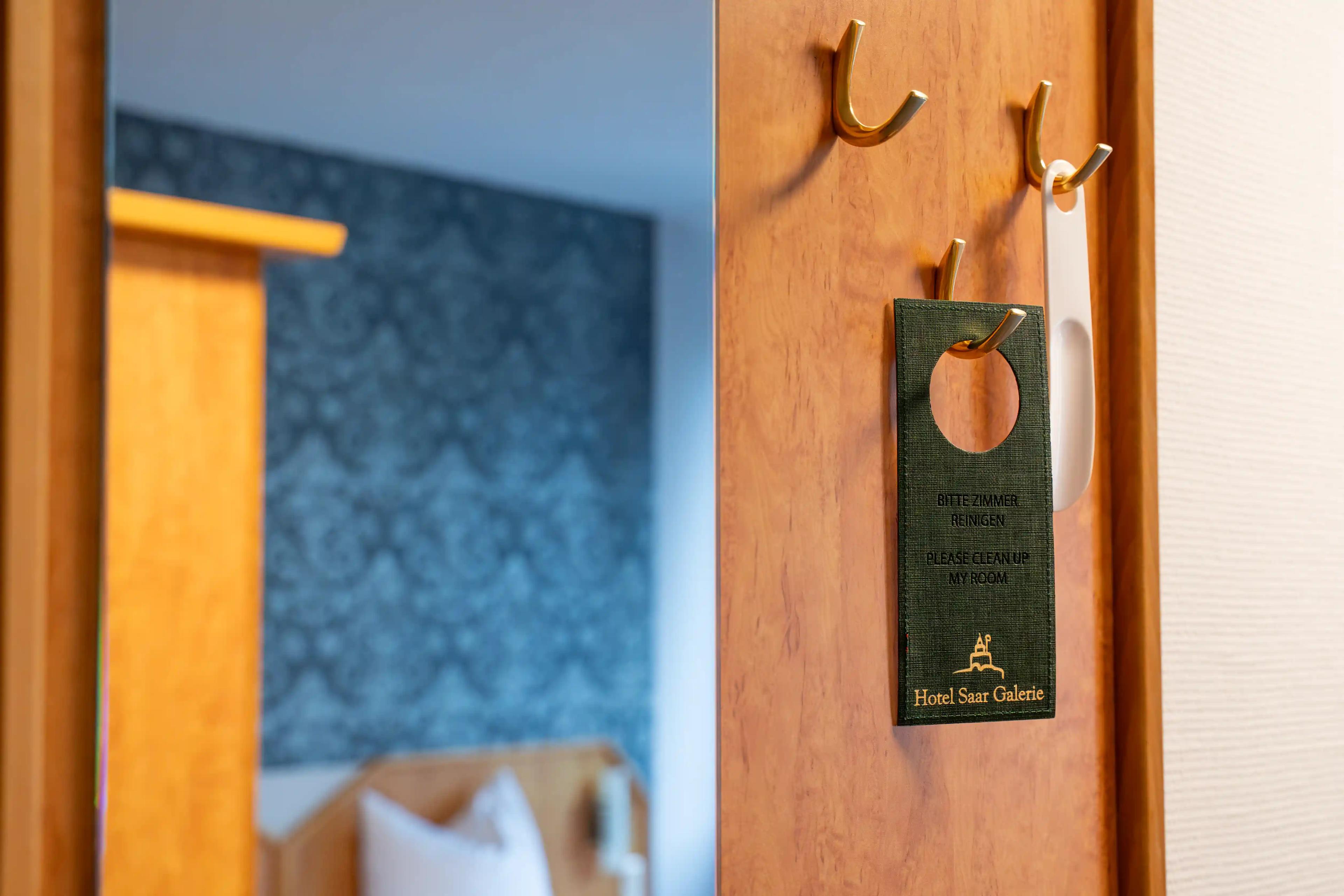 Türhänger mit dem Logo des Hotels Saar Galerie an der Zimmertür