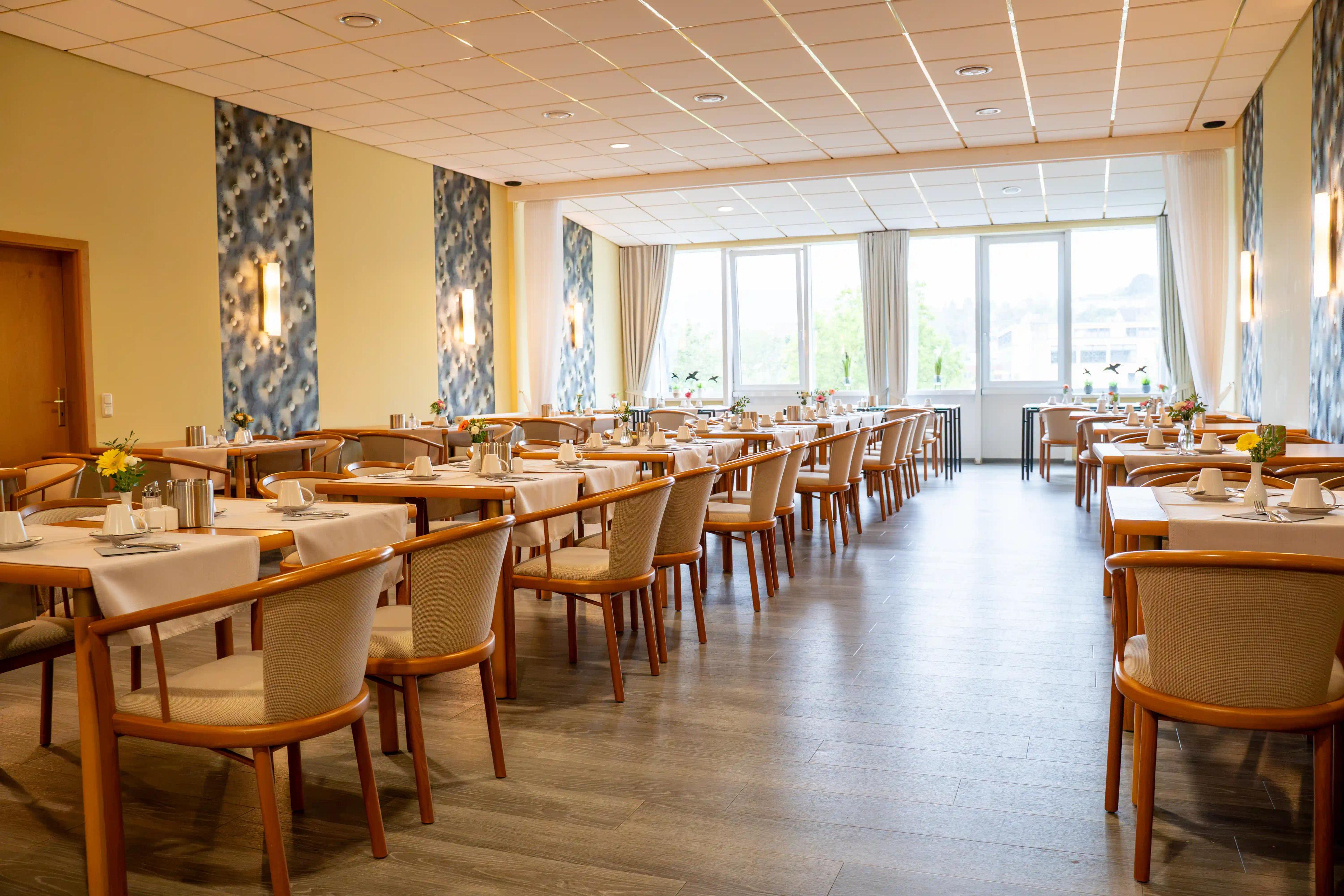 Heller Frühstücksraum mit gedeckten Tischen im Hotel Saar Galerie