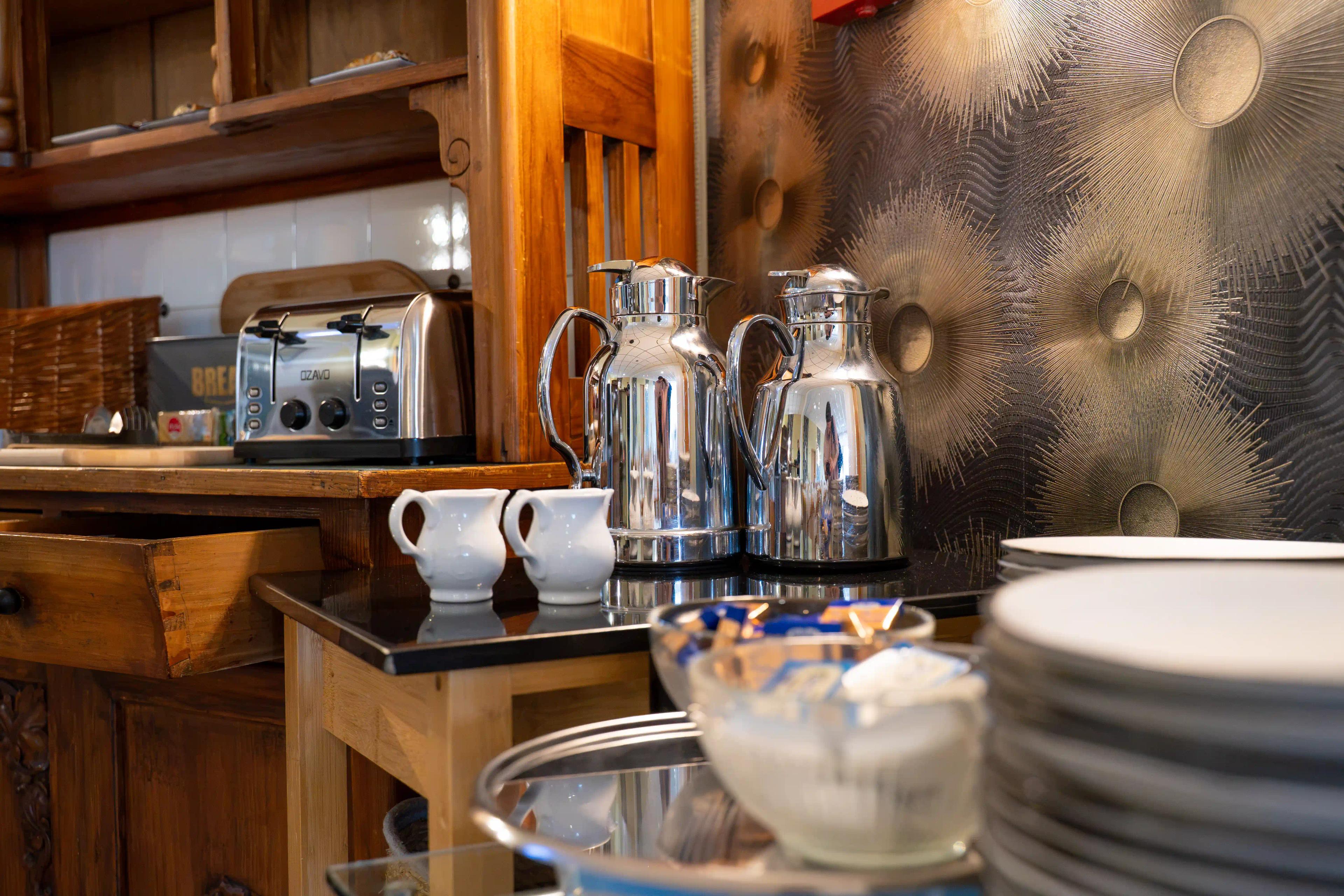 Kaffeekannen und Geschirr am Frühstücksbuffet