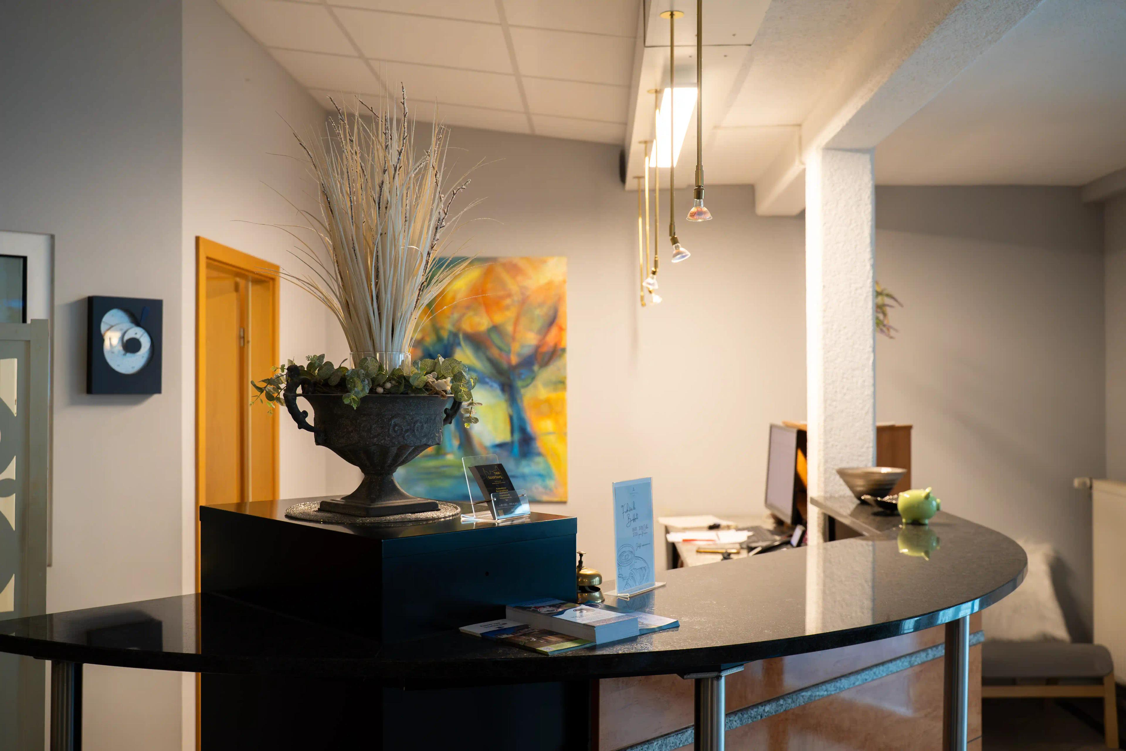 Rezeption mit Blumenvase und Kunst an der Wand