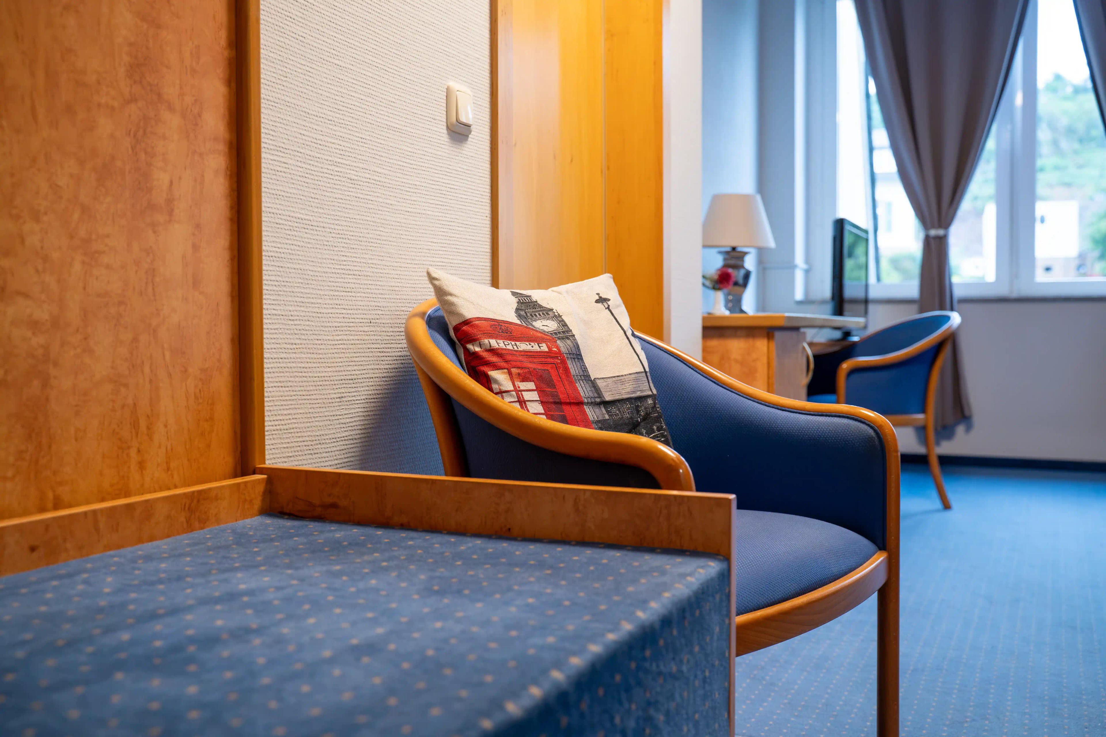 Sitzecke mit blauem Sessel im Standard-Doppelzimmer