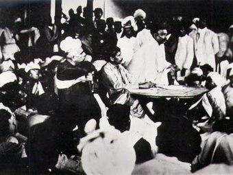 Aurobindo at a Conference of Nationalist Delegates at Surat in December,1907. Aurobindo, sitting with his hands on the table, flanked on his right by G.S. Khaparde and on his left by Lokmanya Bal Gangadhar Tilak, speaking.