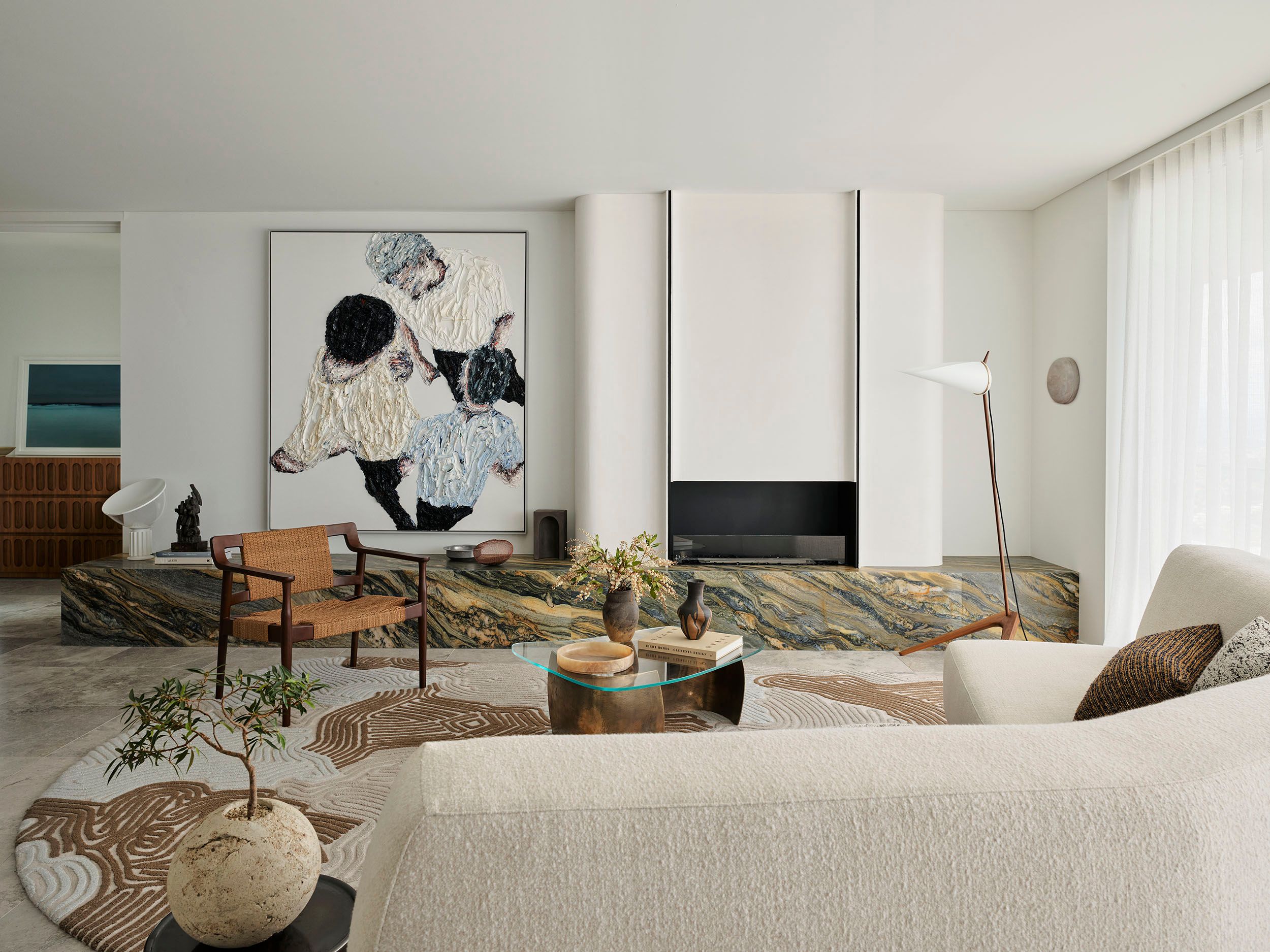 Cloud Surfer living room by Sydney interior design studio Decus, featuring a Clemens Krauss impasto work, veined natural stone, curved fireplace, and softly textured furnishings.
