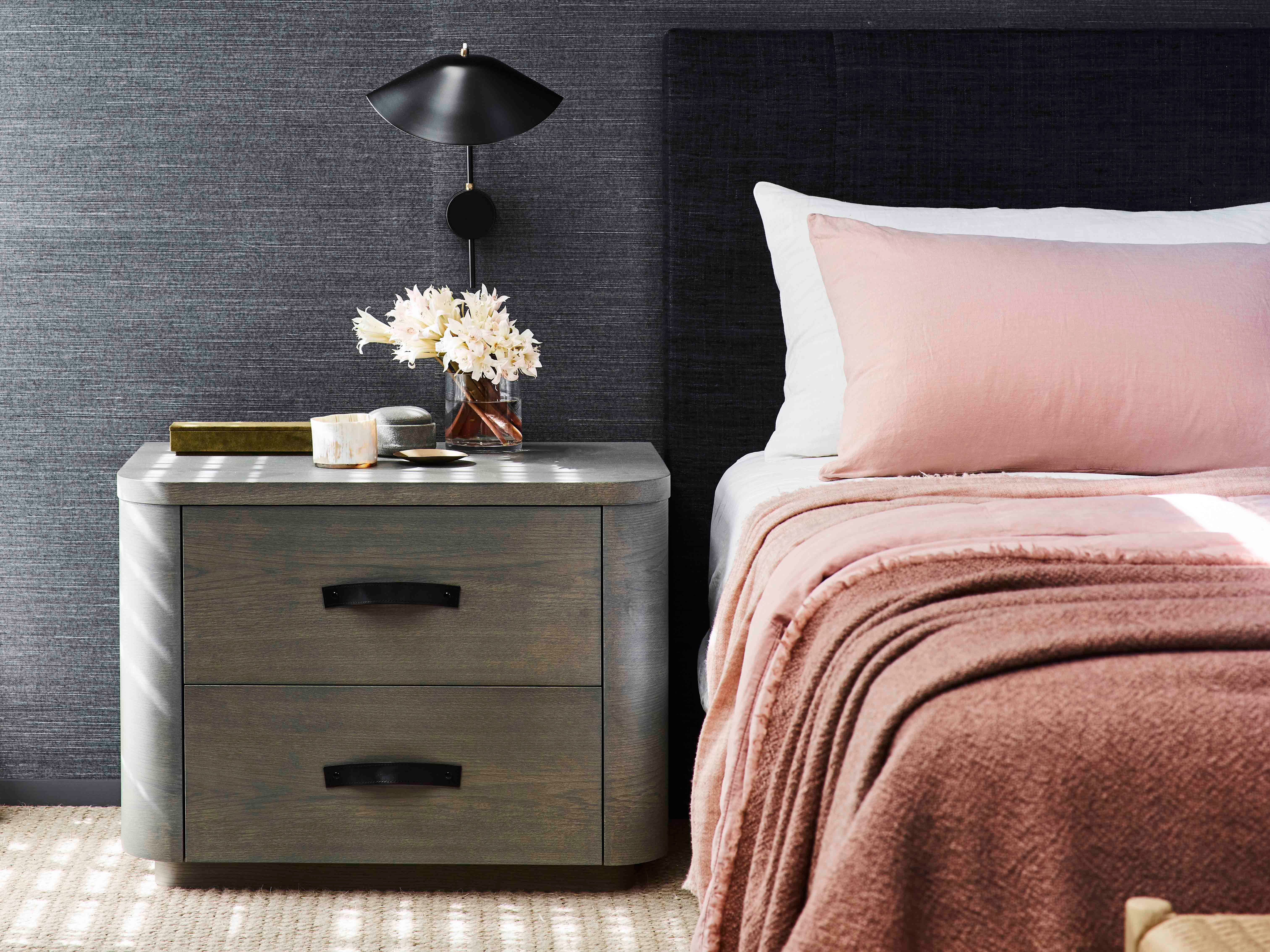 Killcare Main Bedroom dark grasscloth wallpaper pink bedcovers and a grey wash timber bedside table below a black wall light