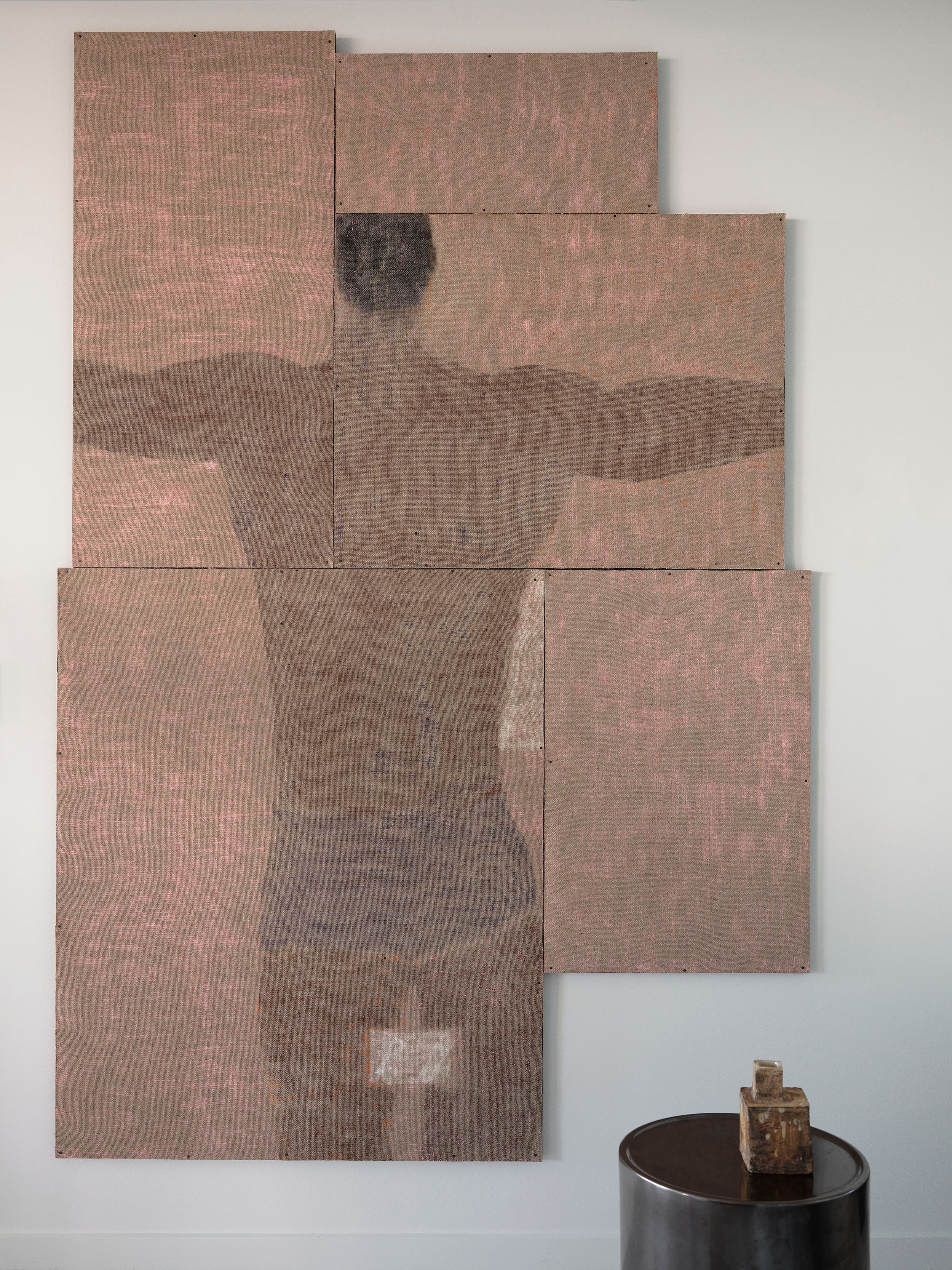 Earth-toned abstract artwork and a sculptural dark side table.