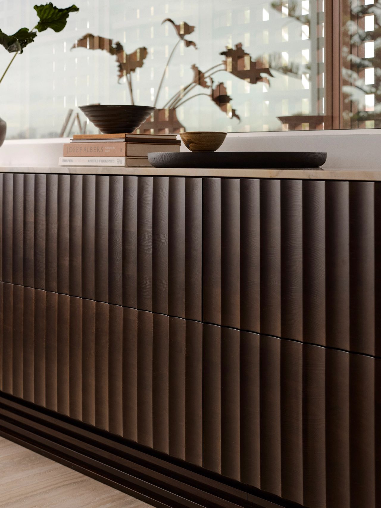Orla Contemporary Brazilian influence dark timber joinery with curved/fluted detail and stone top