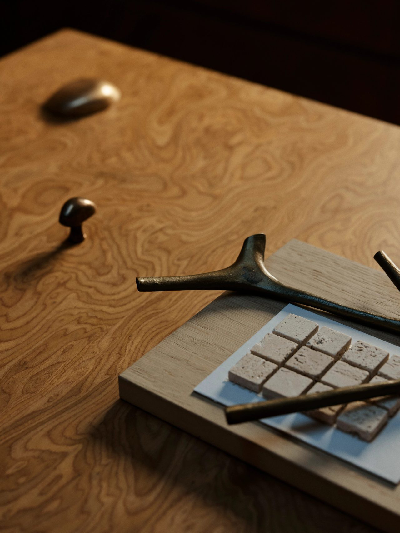 Assorted material and hardware samples displayed against burl timber veneer in decus studio
