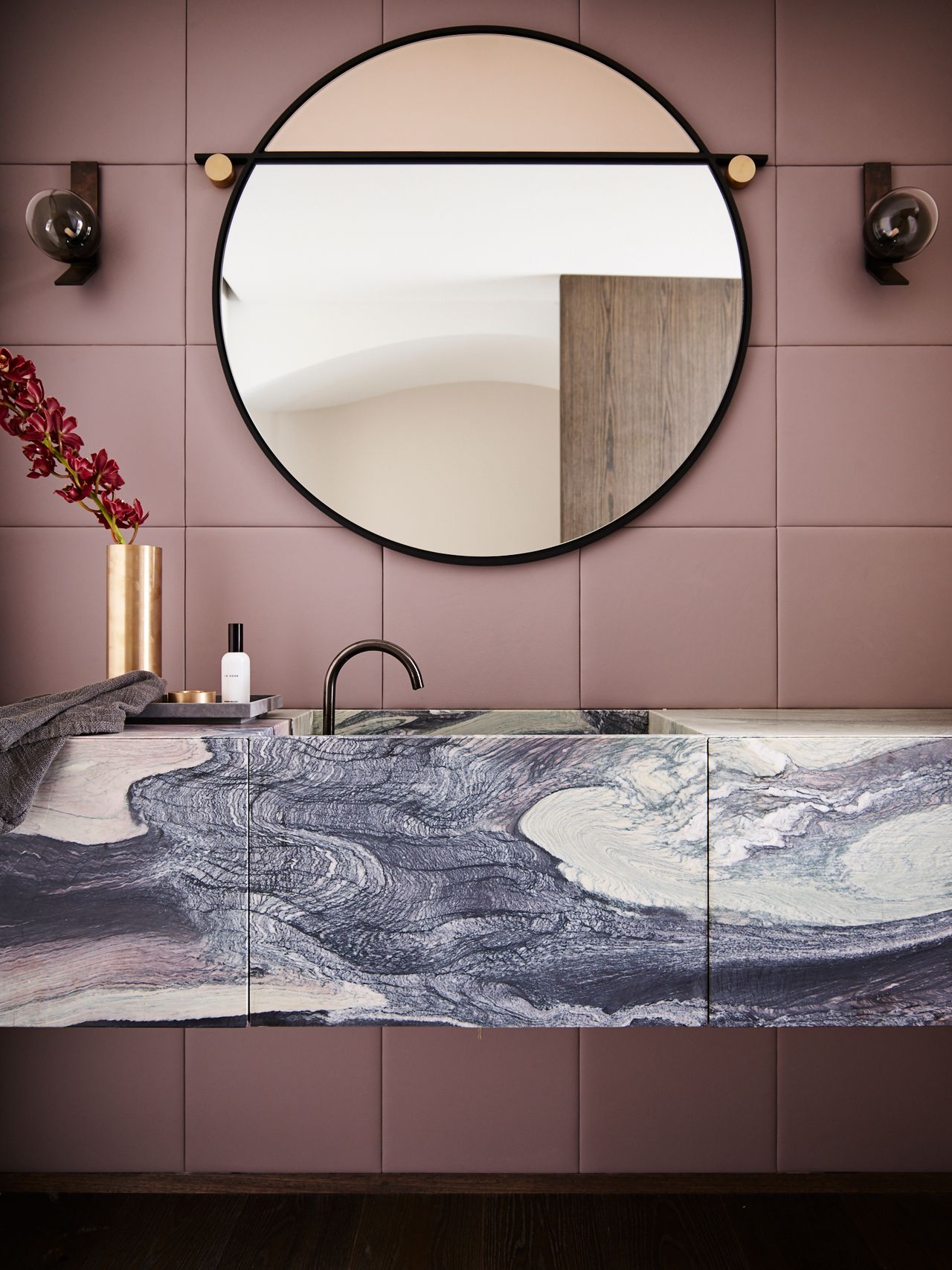 Hill House pink bathroom - purple, pink and cream stone vanity. Circular mirror