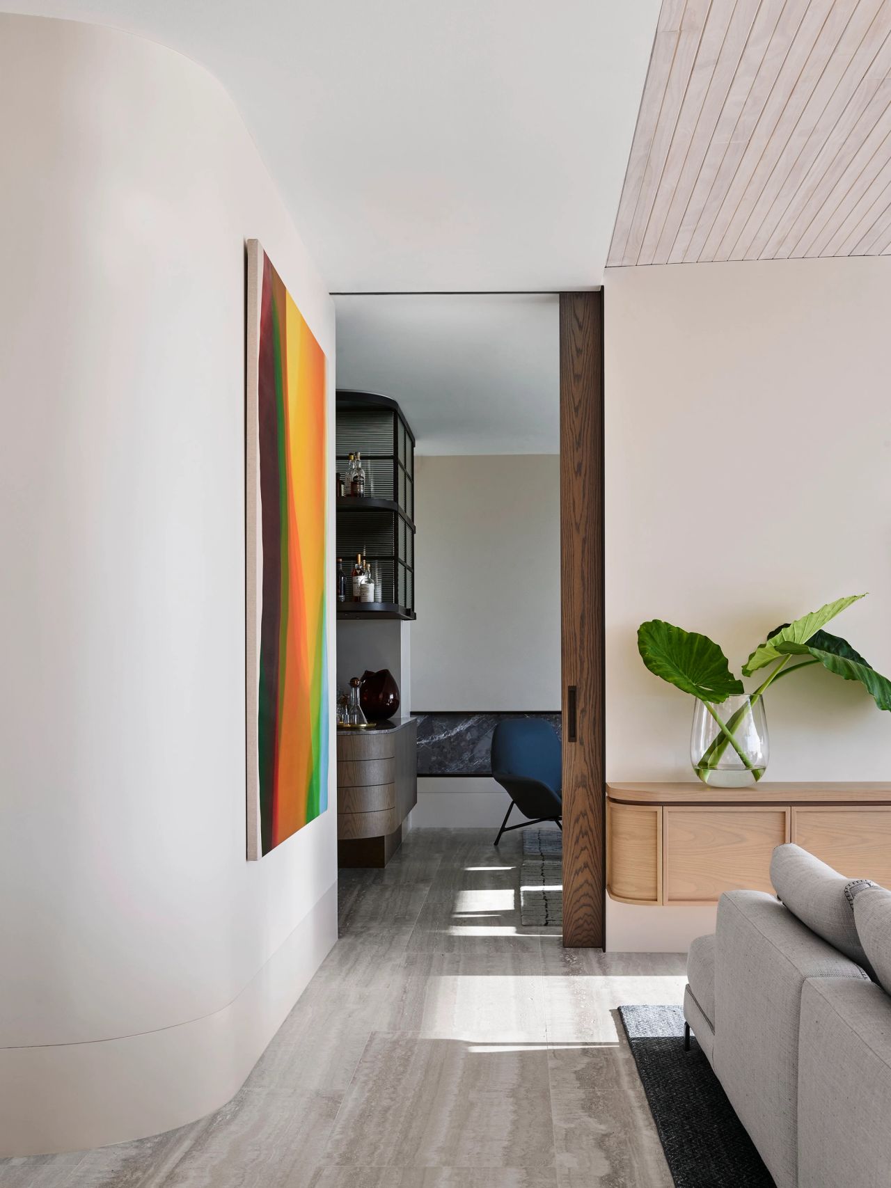 Hill House hallway with colourful artwork and travertine floors
