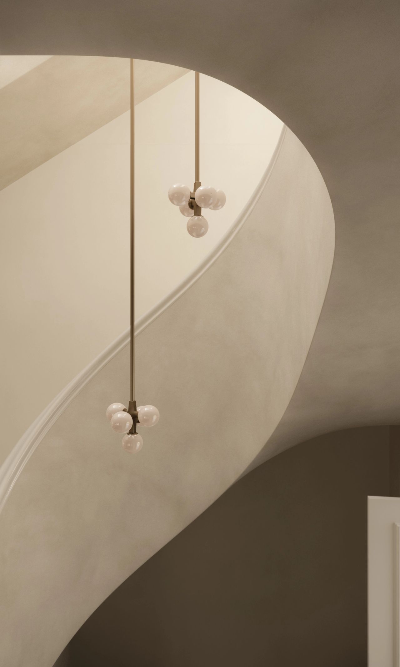 Lady M A sculptural curved staircase with soft cream plastered walls, photographed from below. Two multi-globe brass pendant lights with milk-glass spheres hang at staggered heights, tracing the sweeping curve of the stairwell against a warm, minimal palette.