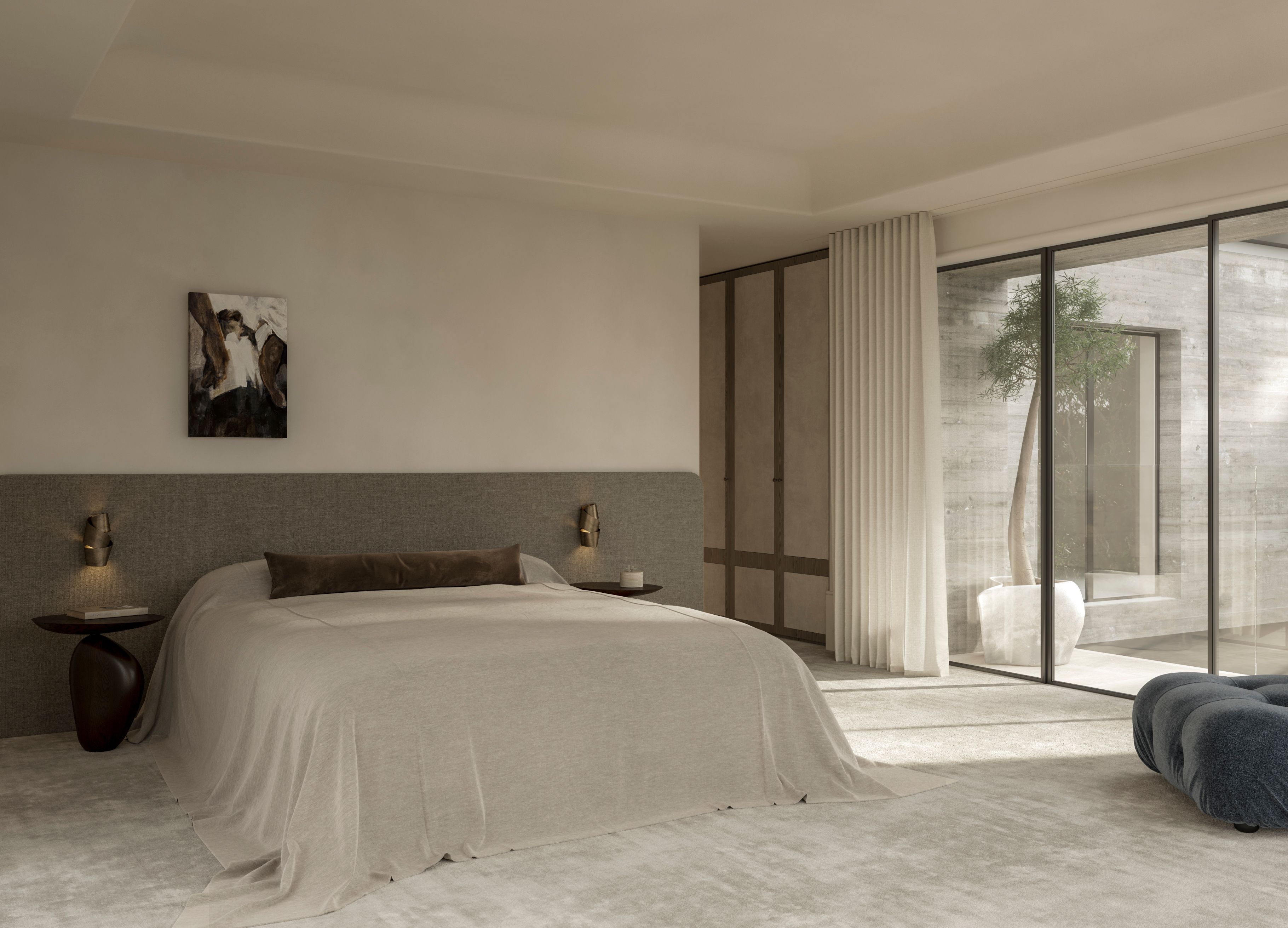 Heavy Metal Bedroom with a wide upholstered bedhead flanked by brass wall lights, sculptural timber side table, framed artwork above, and floor-to-ceiling glass doors opening to a courtyard with a potted olive tree